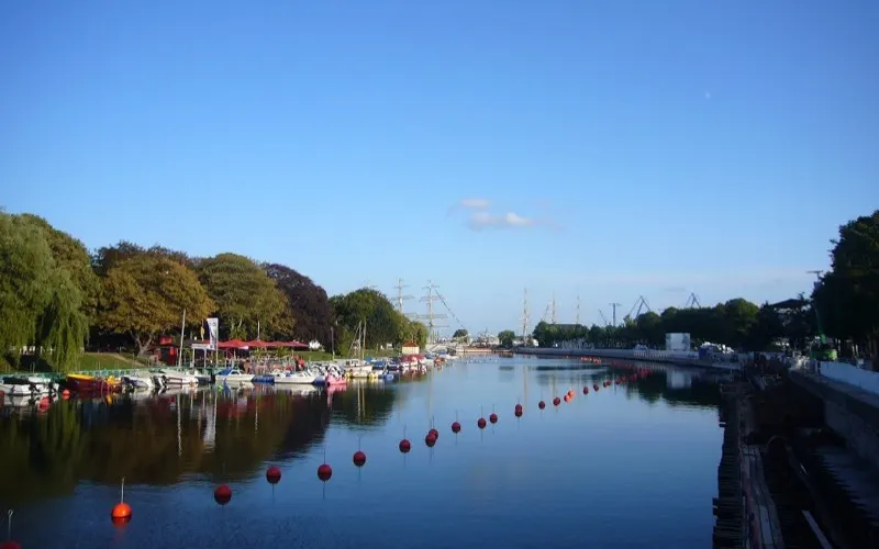 Fiskebåtar och utflyktsbåtar vid kajen längs Alter Strom i Warnemünde